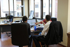 Trois hommes analysant des données au bureau derrière un ordinateur